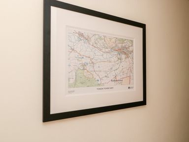 A framed map of Tosson Tower Farm on a beige wall at Coquet View Cottage in Rothbury