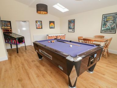 A game room with a pool table dart machine foosball table and table with chairs at The Steadings in Rothbury