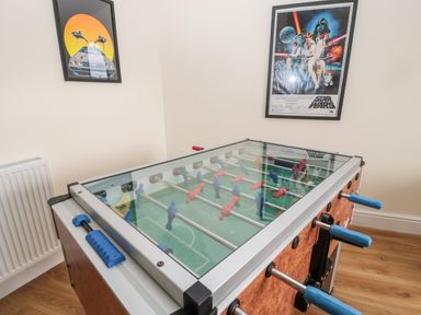 A room with a foosball table and two framed posters on the wall at The Steadings in Rothbury