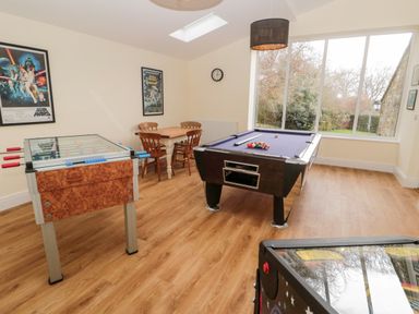 A game room with a pool table foosball table and small dining table with chairs at The Steadings in Rothbury