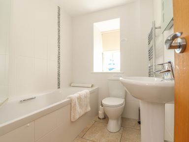 A bathroom with a bathtub a toilet a sink and a window at An Gwel in Sennen