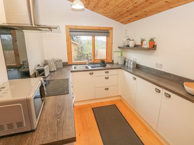 A kitchen with wooden ceiling white cabinets and appliances at Willow Lodge in St Florence