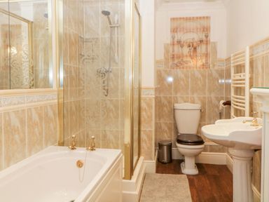 A bathroom with a bathtub shower toilet sink and a wall mural at Holcombe House in Torquay