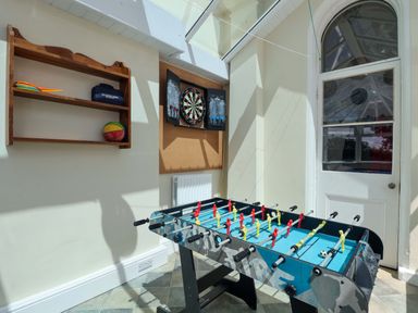 A games room with a foosball table and dartboard at Holcombe House in Torquay