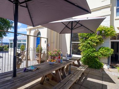 An outdoor area with a table and beverages at Holcombe House in Torquay