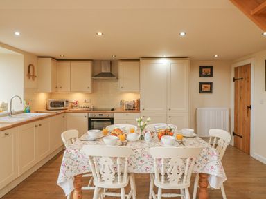A kitchen with a dining table set for breakfast at The Apple Barn at Wyke Farm in Lyme Regis