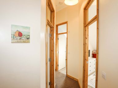 A hallway with wooden door frames and a painting on the wall at Ffynnon Bach in Deiniolen