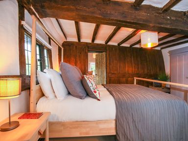 A bedroom with a large bed and wooden ceiling beams at 3 Masons Court in Stratford-Upon-Avon