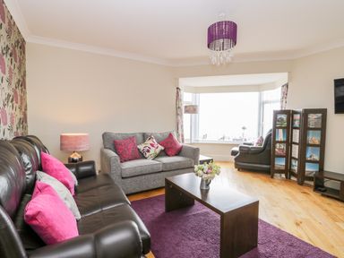 A living room with sofas and cushions a coffee table and a window with a view at The Gansey Girl in Bridlington
