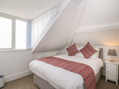 A bedroom with a bed pillows and a lamp on a nightstand at The Gansey Girl in Bridlington