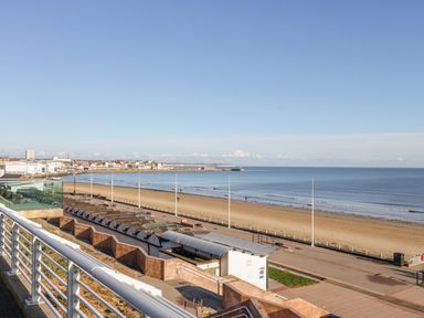 A beach view with a promenade and buildings in the distance at The Gansey Girl in Bridlington