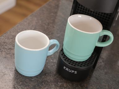Two ceramic mugs on a countertop one on a coffee machine and one beside it at Tremethic in Trewoon