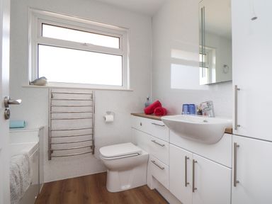 A bathroom with a toilet sink towels and a heated towel rail at Tremethic in Trewoon