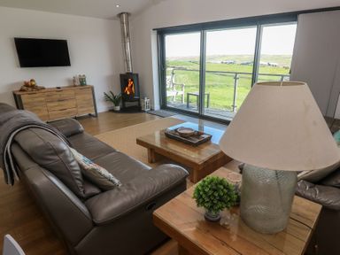 A living room with a sofa and coffee table at Sandpiper in Perranporth