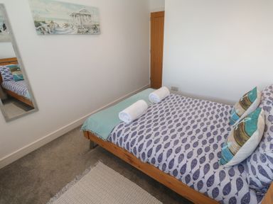 A bedroom with a bed and towels at Sandpiper in Perranporth