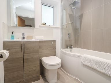 A bathroom with a bathtub and toilet at Sandpiper in Perranporth