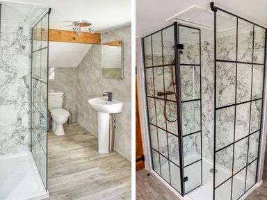 A bathroom with a toilet sink and glass shower enclosure with marble walls at Conquer Hall in Hendomen near Montgomery