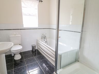 A bathroom with a toilet pedestal sink bathtub and shower at Croghan in Portsalon