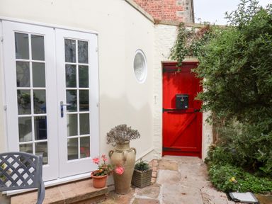 Double doors and a red door in a garden at 20A St Hilda's in Whitby