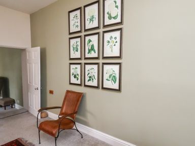A living room with framed artwork on the wall at 20A St Hilda's Whitby