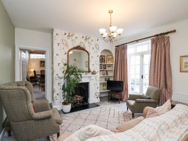 A living room with a sofa, armchair, and fireplace at 20A St Hilda's in Whitby