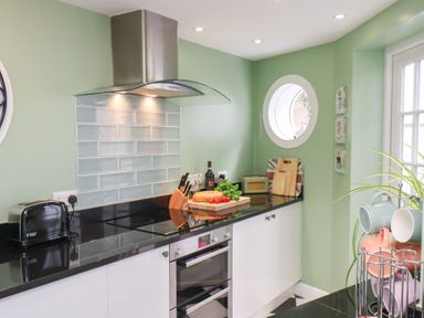 A kitchen with a black countertop and appliances at 20A St Hilda's in Whitby