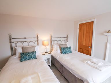 A bedroom with two beds and a nightstand at 20A St Hilda's in Whitby