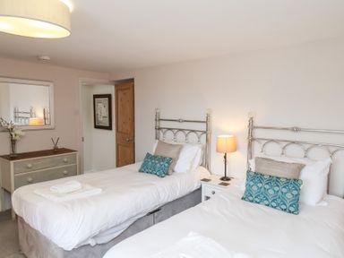 A bedroom with two beds and a dresser at 20A St Hilda's in Whitby