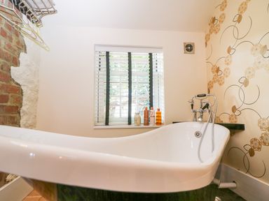 A bathroom with a clawfoot bathtub and a window with blinds at The Hemmel in Faringdon