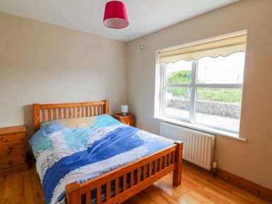 A bedroom with a wooden bed and two wooden bedside tables at Doornogue in Churchtown near Fethard-on-Sea