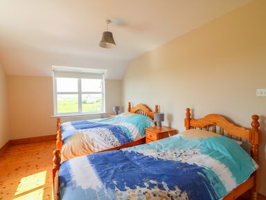 A bedroom with two wooden beds and blue patterned bedding at Doornogue in Churchtown near Fethard-on-Sea