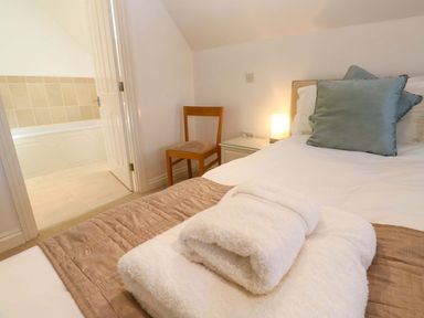 A bedroom with a bed and a chair at Meridian in Carbis Bay