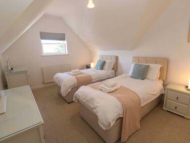 A bedroom with two beds and a television at Meridian in Carbis Bay