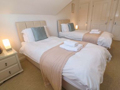 A bedroom with two beds and a nightstand at Meridian in Carbis Bay