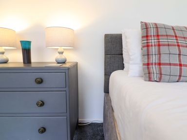 A bedroom with a bed and nightstand at Glyn Morfa in Harlech