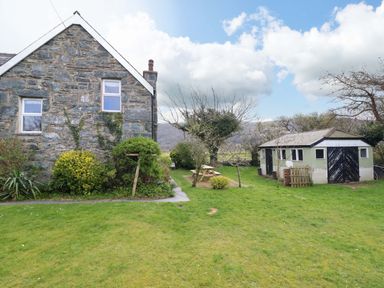 A garden with a house and shed at Glyn Morfa Harlech