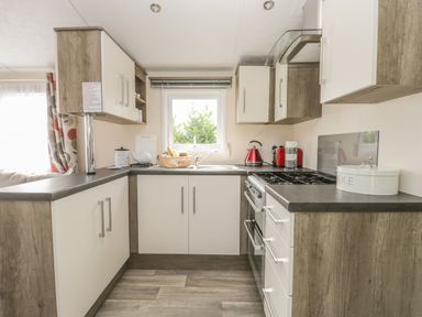 A kitchen with a stove kettle and toaster on the counter at The Maple in Cloughton