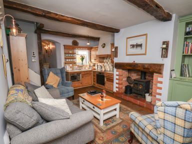A living room with a sofa and fireplace at Cobbles House in Whitby