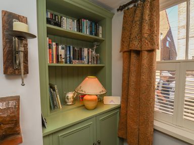A reading nook with a bookshelf and lamp at Cobbles House Whitby