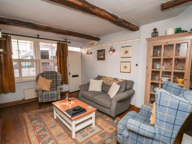 A living room with a sofa and armchairs at Cobbles House in Whitby