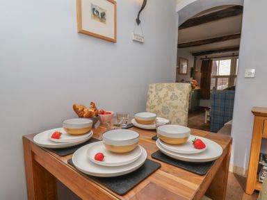 A dining table set with plates and fruits at Cobbles House, Whitby