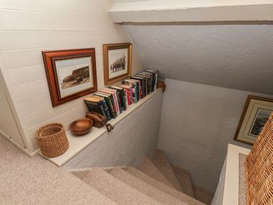 A stairwell with books and frames at Cobbles House in Whitby