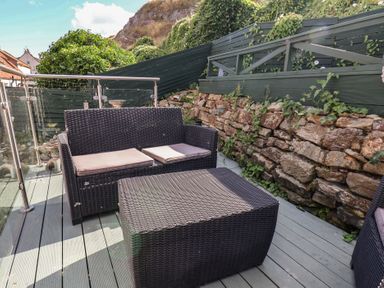A garden with a sofa and coffee table at Cobbles House in Whitby
