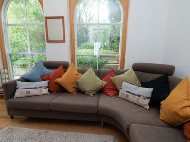 A living room with a sofa and cushions at Damson Cottage in Whitby