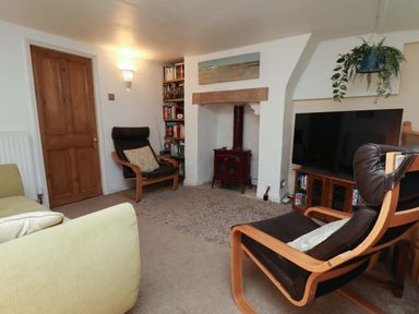 A living room with a chair and a television at Damson Cottage in Whitby