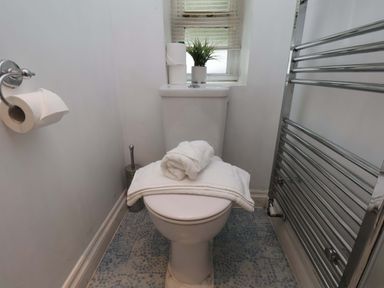 A bathroom with a toilet and towels at Damson Cottage in Whitby