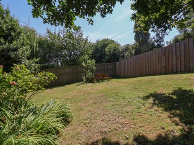 A garden with a bench and grass at Damson Cottage in Whitby