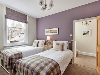 A bedroom with two single beds and a bedside table with a lamp at Harbour House in Whitby
