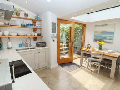 A kitchen with a dining table set near glass doors opening to an outdoor area at The Cottage in Sandsend