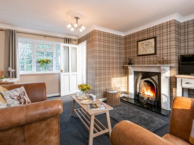 A living room with a fireplace coffee table and leather armchairs at Esk View Cottage in Grosmont